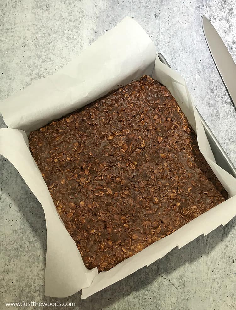 chocolate oat bar recipe in parchment paper lined pan after hardening in refrigerator