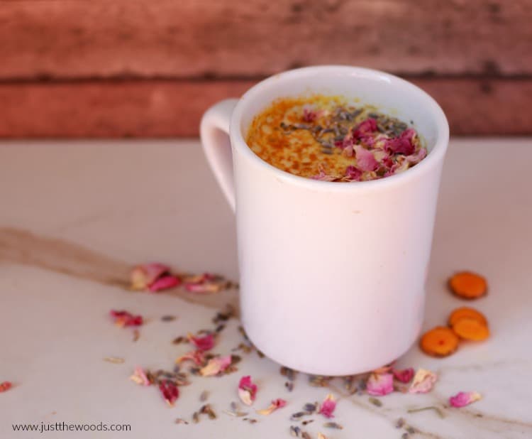 golden milk in white mug with pink flowers and turmeric