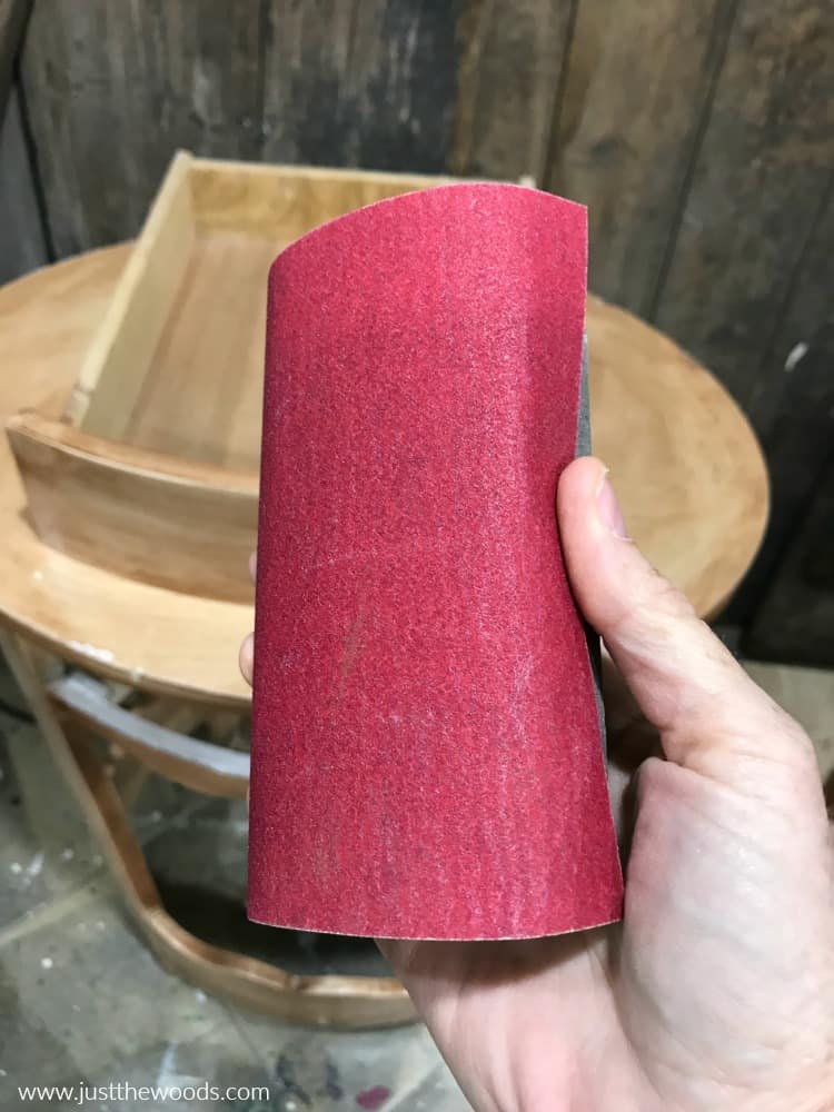 sandpaper wrapped around sanding block, prepping wood furniture for paint