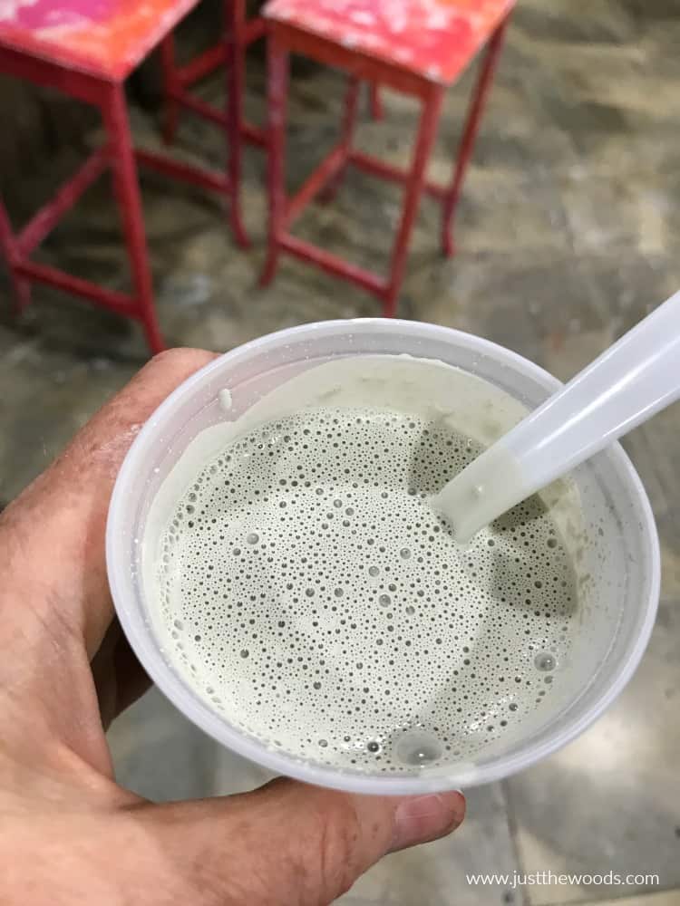 diluted paint with water to make a whitewash in plastic cup