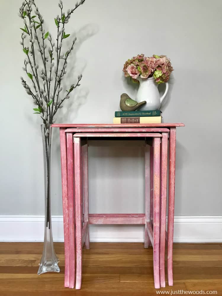 pink nest of tables, tables with two books and floral vase