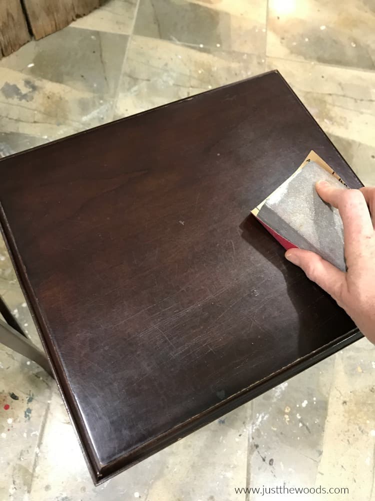 sanding block sanding top of brown nesting table