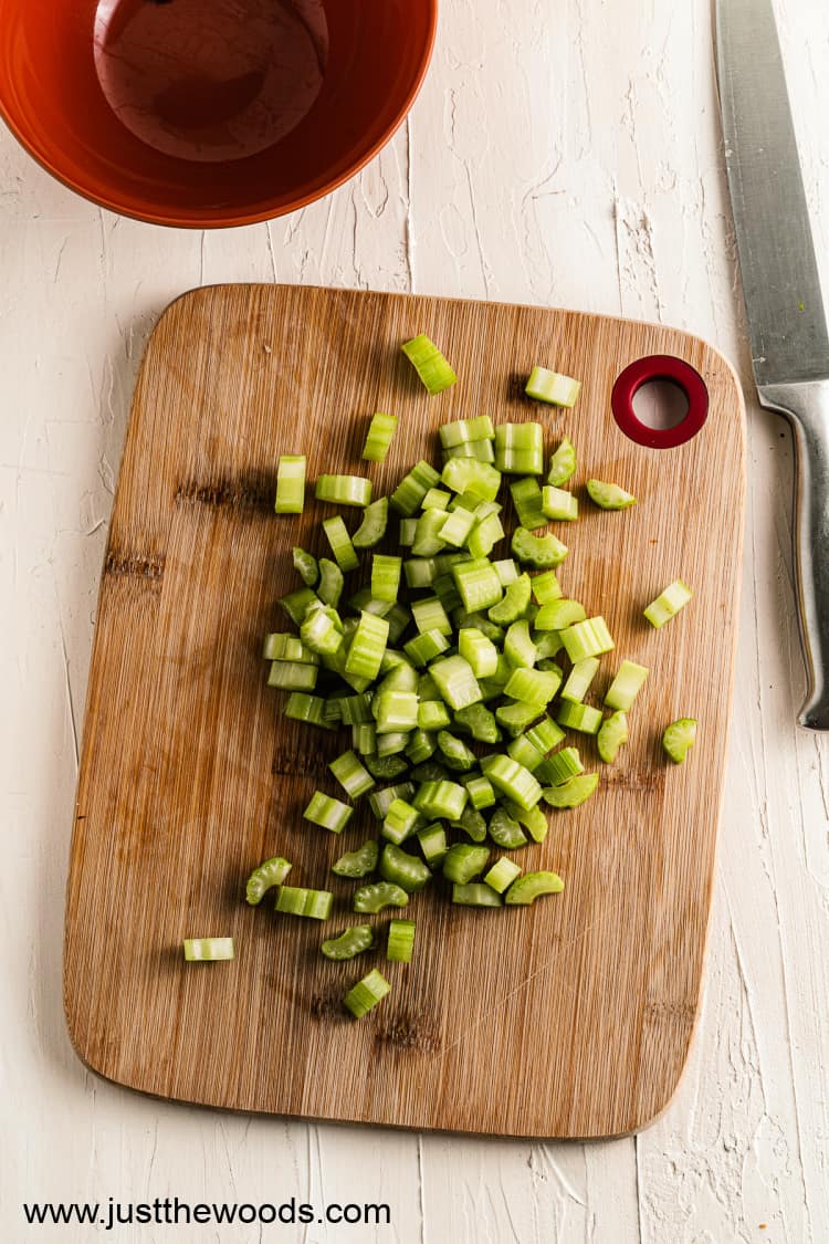 chopped celery on wooden cutting board for Waldorf salad