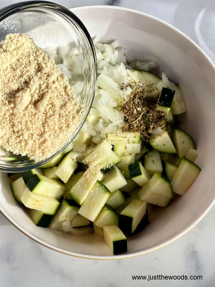 adding cashew flour to paleo zucchini casserole ingredients bowl