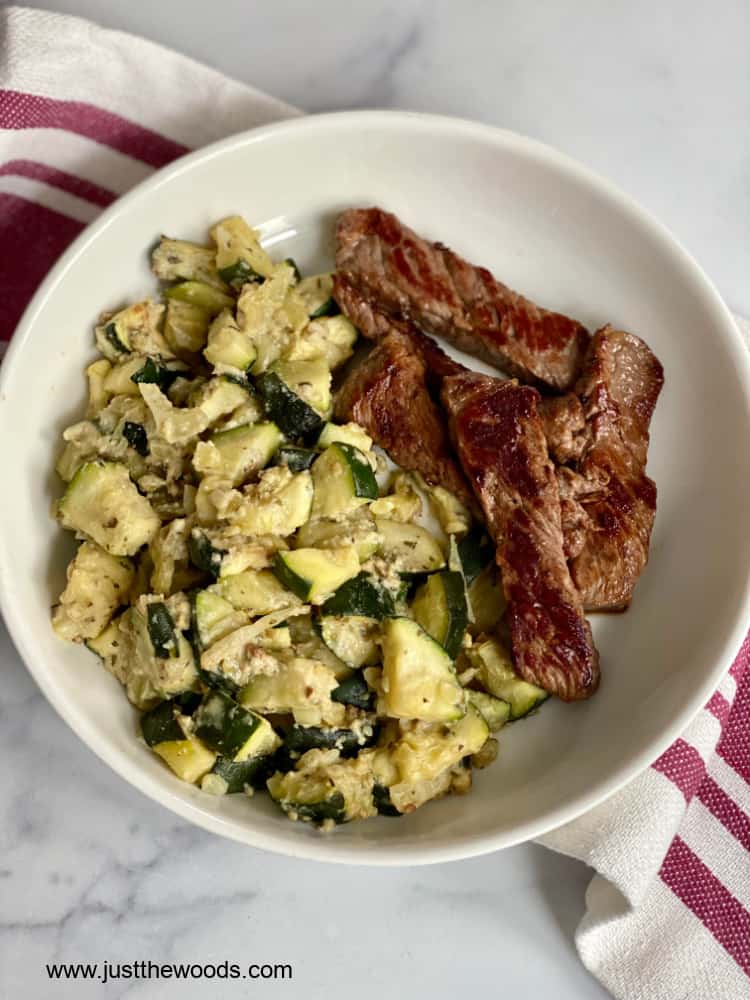 baked paleo zucchini casserole in a white dish with steak strips