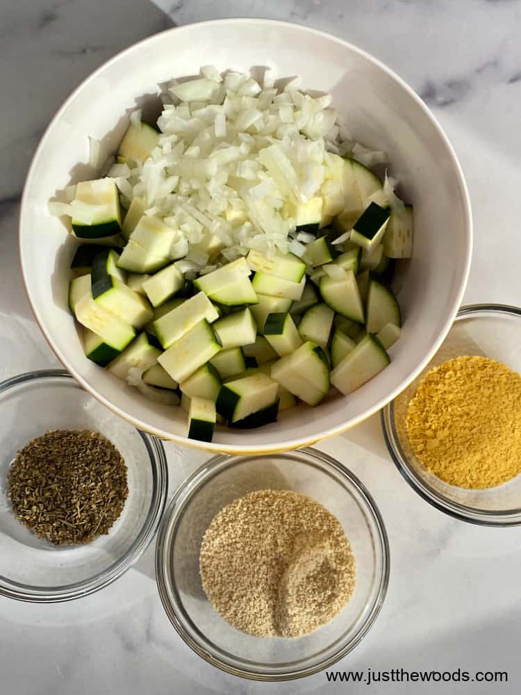 cubed zucchini in a bowl with ingredients to make baked zucchini