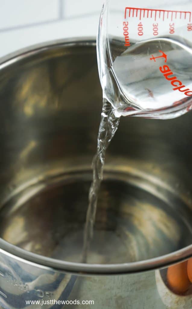 pouring water into a bowl to cool hard boiled eggs