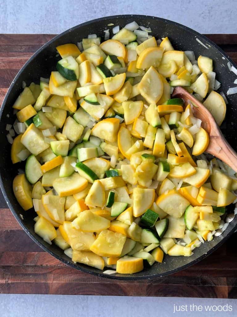 green zucchini and yellow squash in skillet with onions