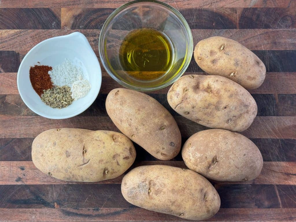 potatoes and a little oil on cutting board 