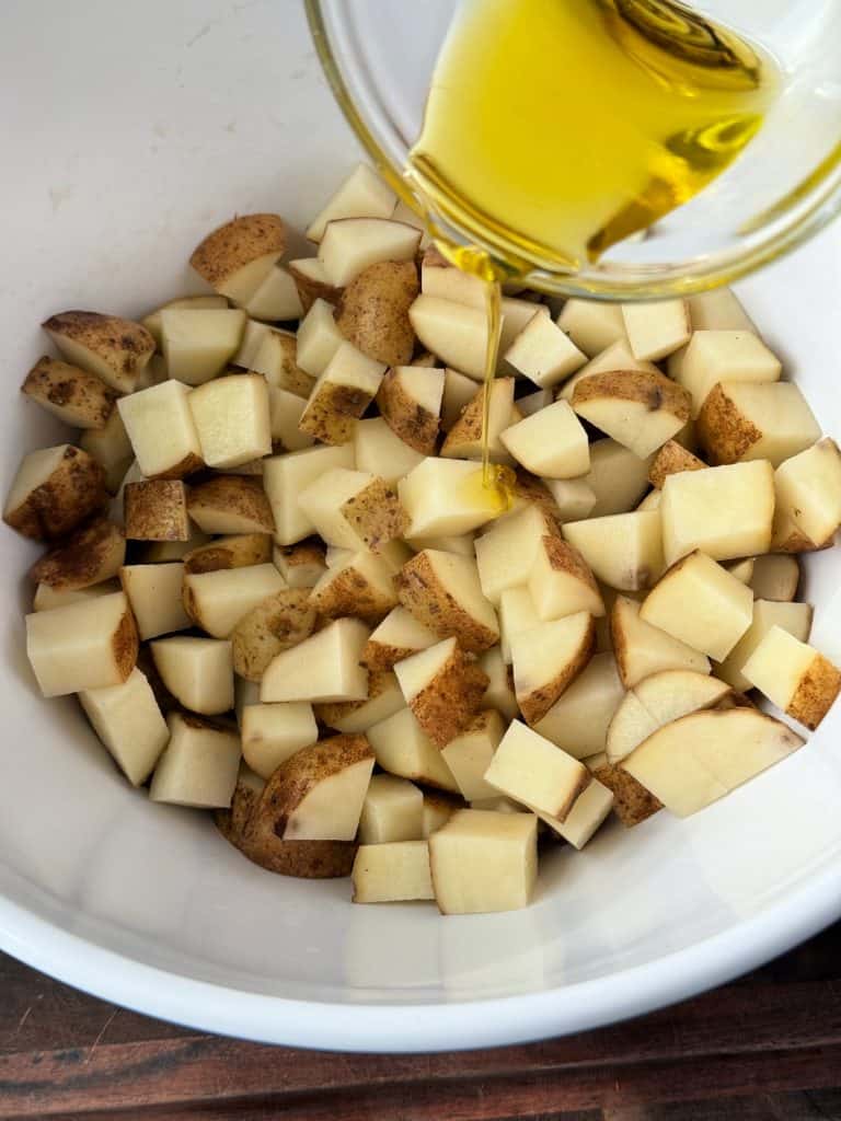 olive oil on cut potatoes 