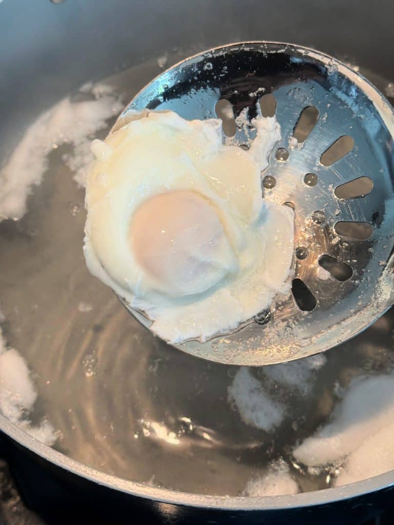 remove poached eggs from water with slotted spoon 
