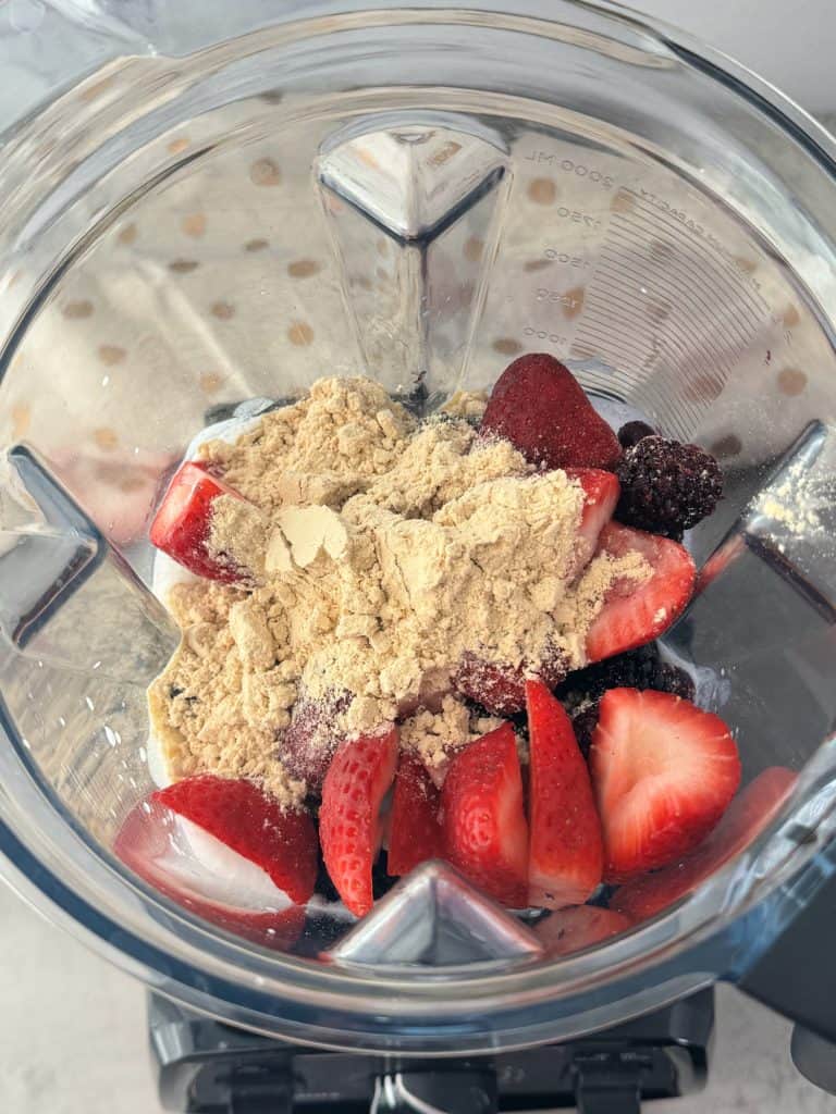 vanilla protein powder with strawberries in blender