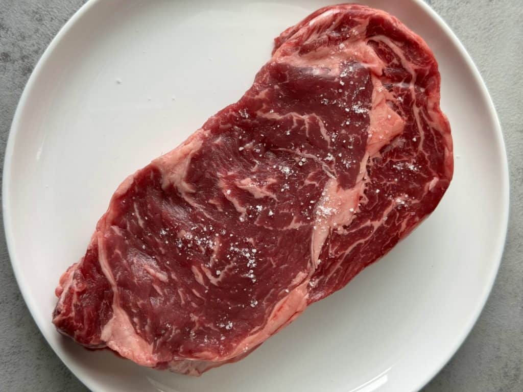 season ribeye steak with salt 