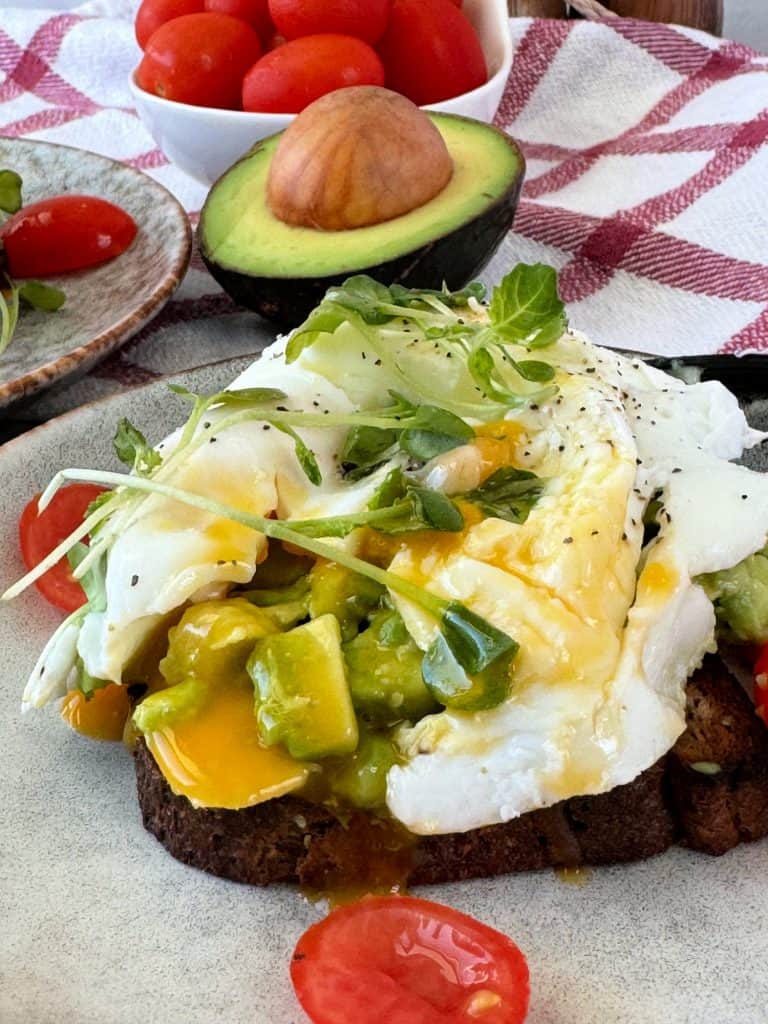 easy Poached Eggs Recipe on avocado toast with tomatoes