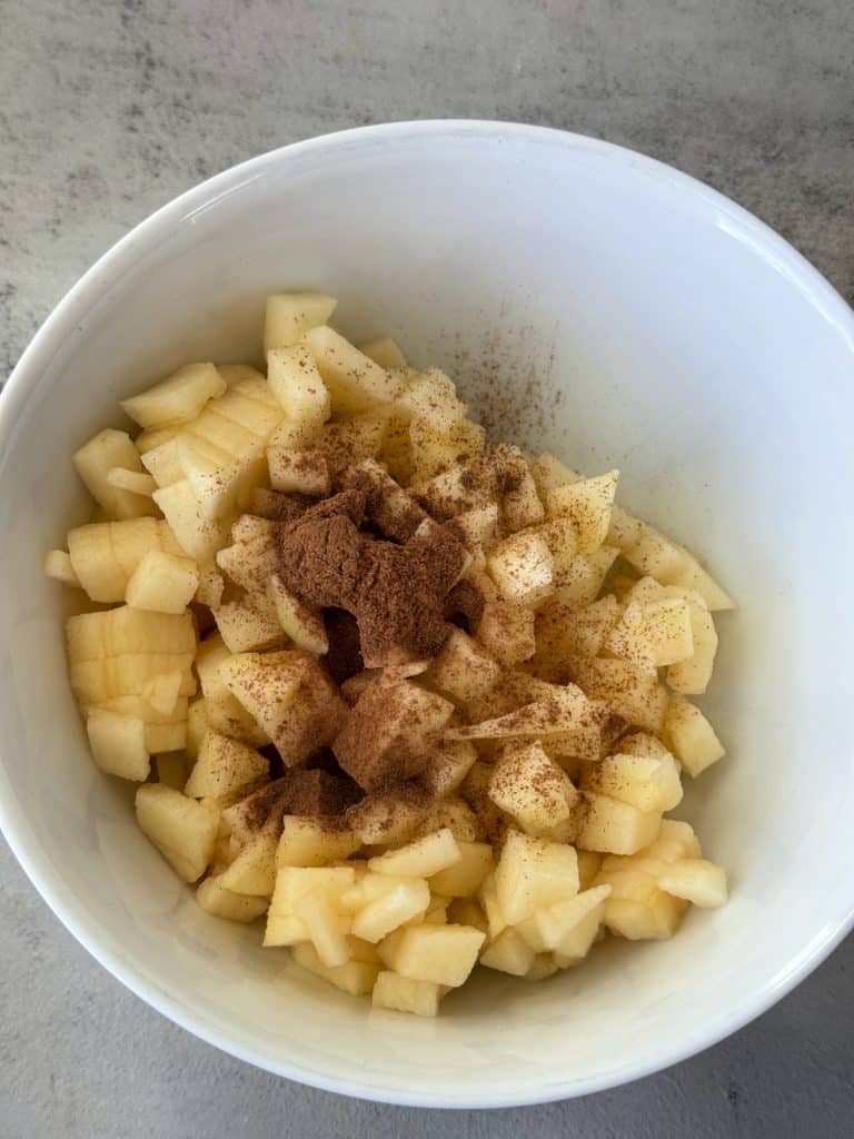 diced apples in bowl with cinnamon 