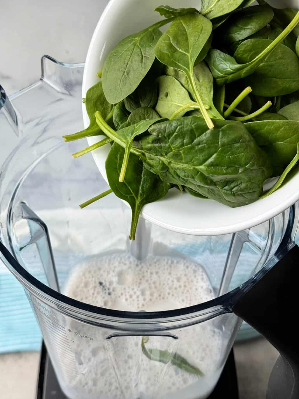 baby spinach leaves with almond milk in high speed blender