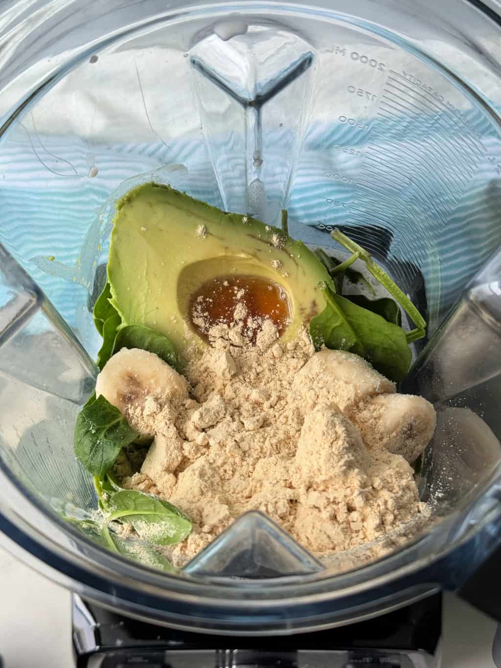 green smoothie with protein powder ingredients in blender