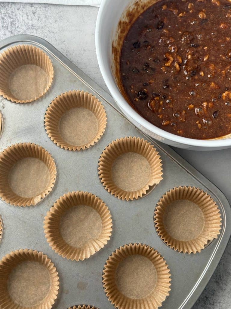 chocolate walnut muffins batter in bowl and paper liners in pan