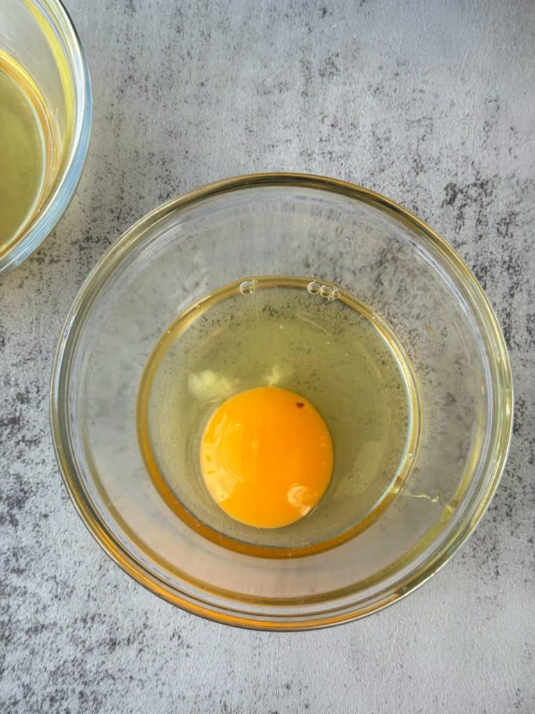 cracked raw egg in small ramekin dish