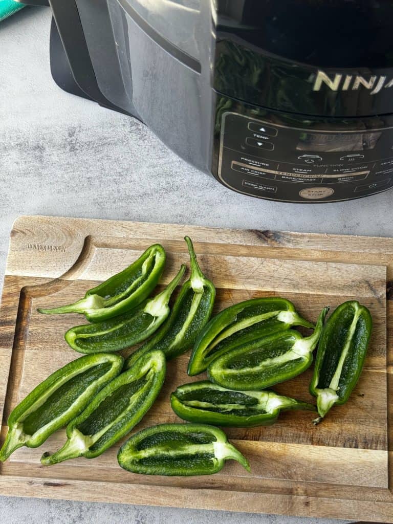 sliced jalapenos with seeds removed on cutting board 