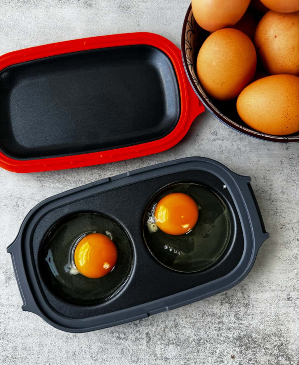 raw eggs in circles of egg maker