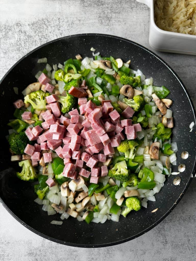 diced ham in skillet with cooked veggies