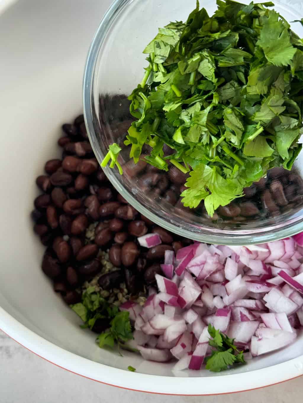 chopped cilantro in glass dish adding to bowl