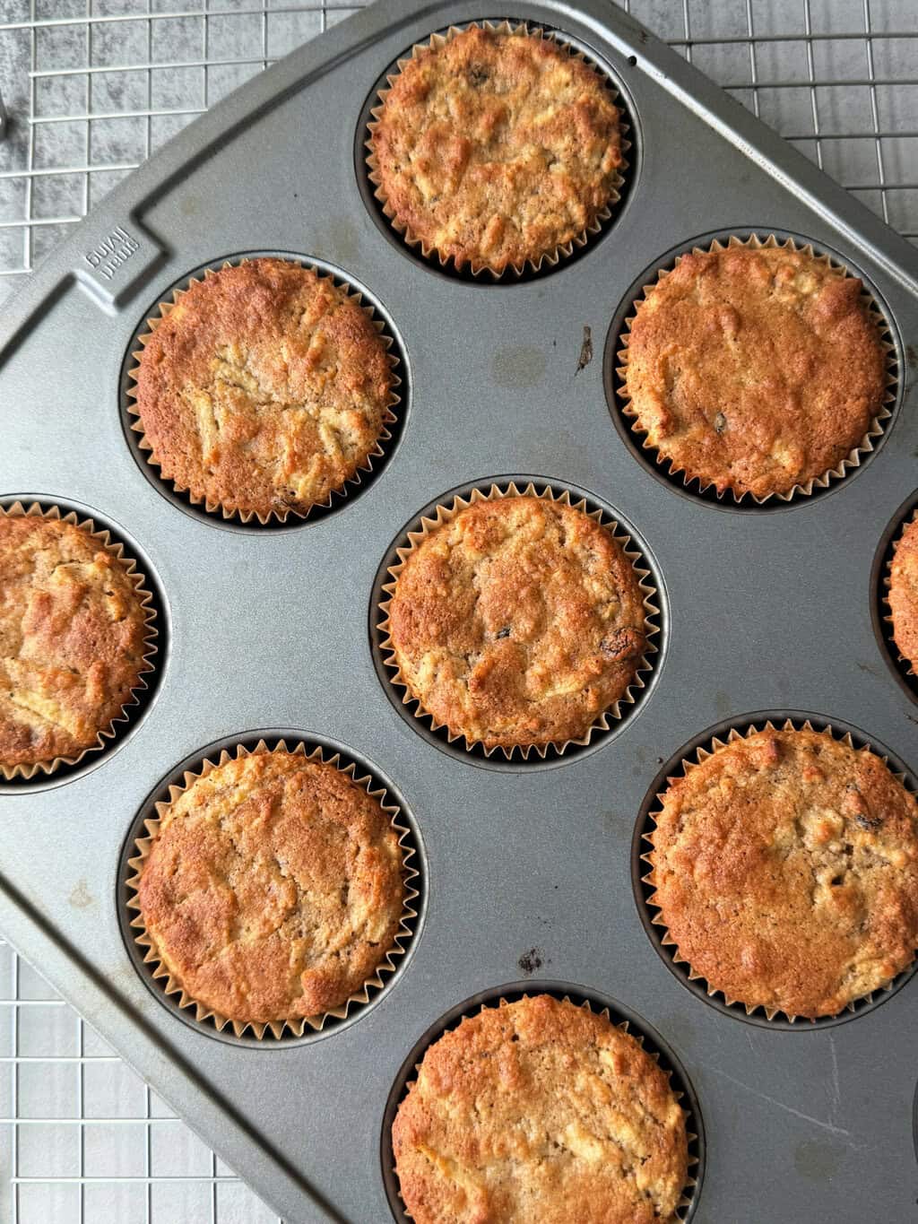 baked muffins in tin on wire rack