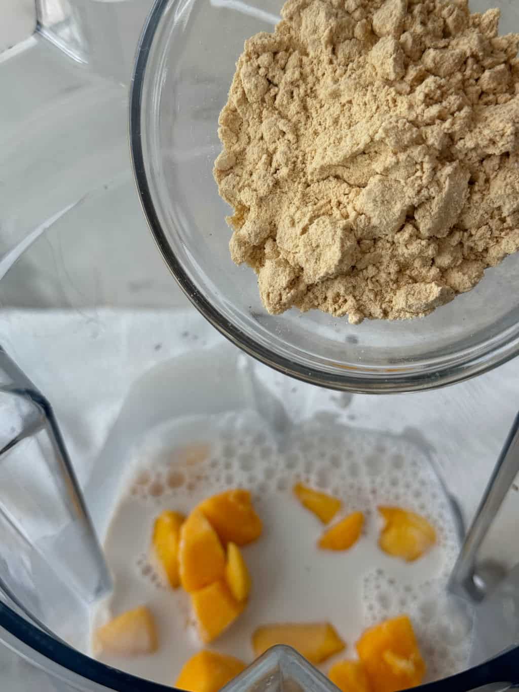 vanilla plant based protein powder into blender for smoothie