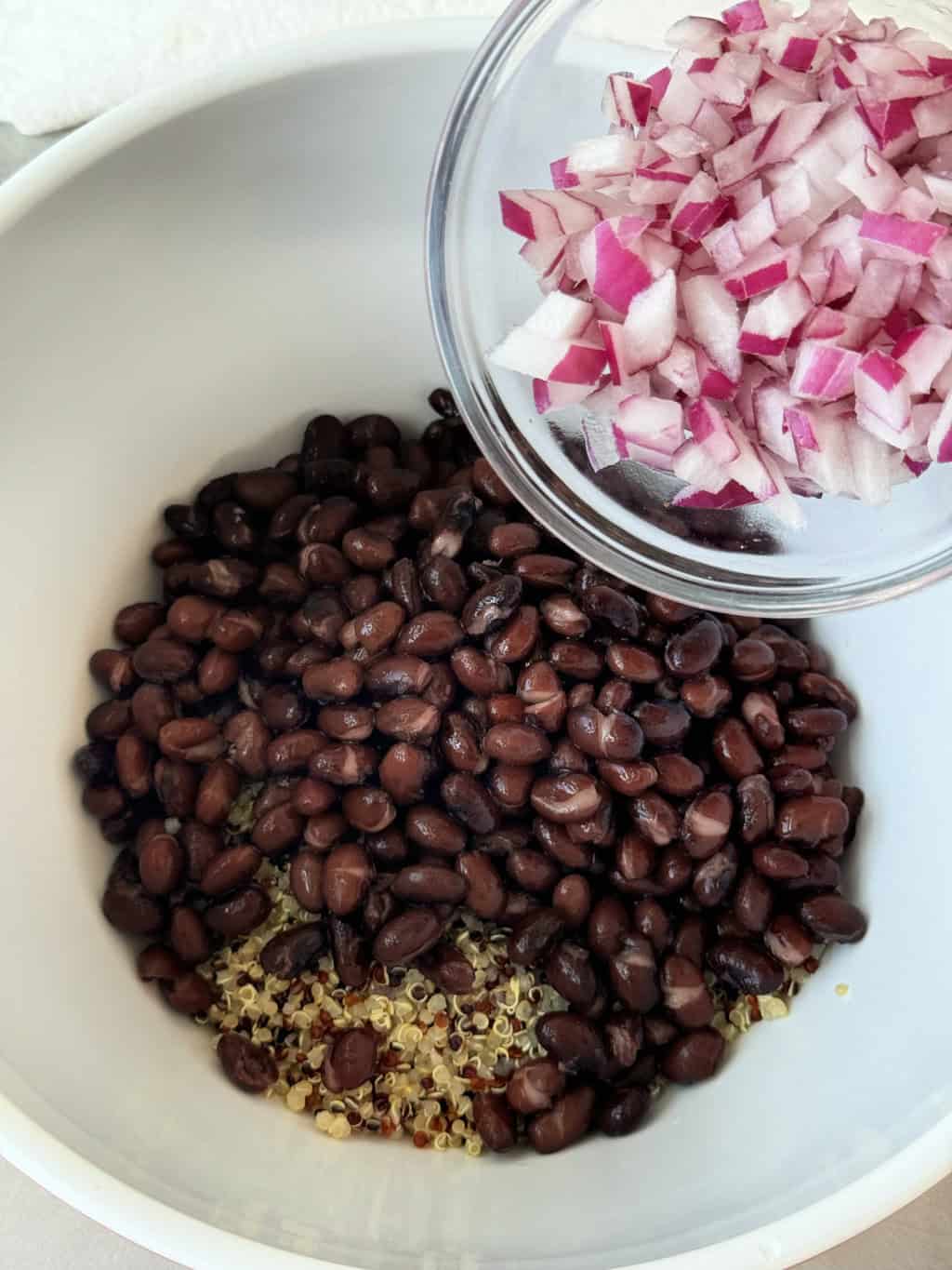 diced red onions in bowl with black beans and tricolor quinoa